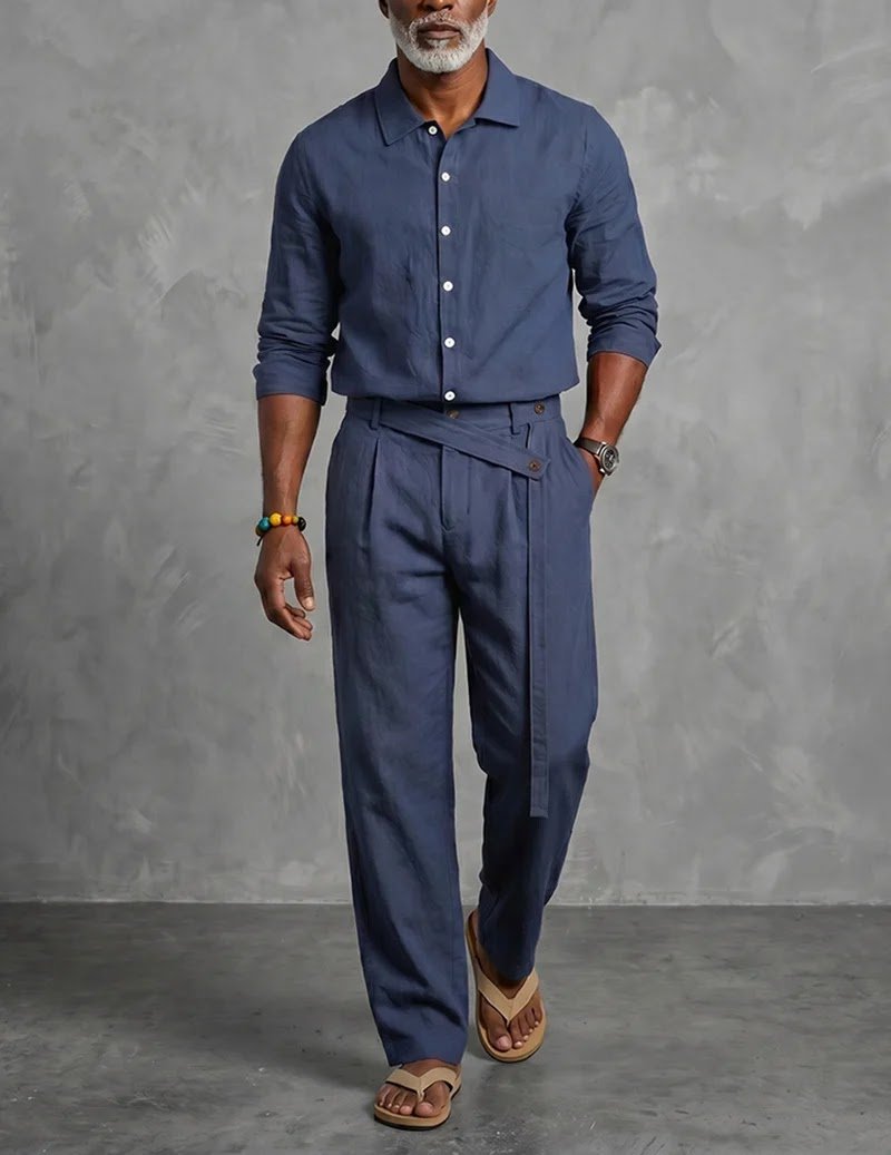 Best Men's Mandarin Collar Long Sleeve Linen Shirt and Belted Pants Set for Summer Resort Outfits in the UK and USA A stylish man standing outdoors wearing a navy blue Ekouaer men's casual linen mandarin-collar long-sleeve shirt and matching belted pleated pants two-piece set, accessorized with sandals to highlight sophisticated resort wear and summer fashion for the UK and USA.